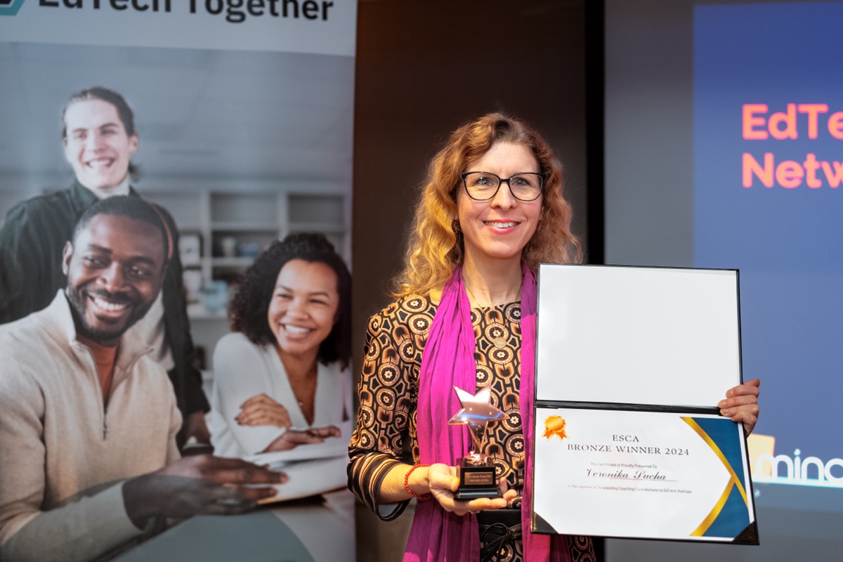 An ESCA 2024 coach with their award